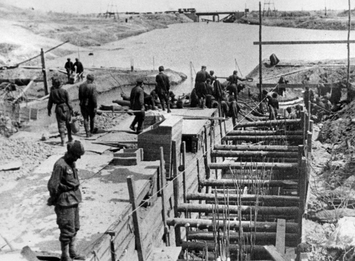 ​A photo has survived in which soldiers of 10th Division of the internal troops of the NKVD are building the dugout of the division headquarters. In this dugout, the command post of 92nd OSBR was located. In the distance you can see the bridge and railway running along the banks of the Volga - Unknown Stalingrad: The City Garden | Warspot.net